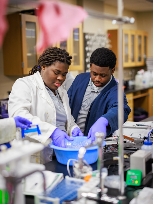 Hattiesburg High students Myah Eaton and Jemele Moore perform an experiment using an icy bath in their school laboratory.