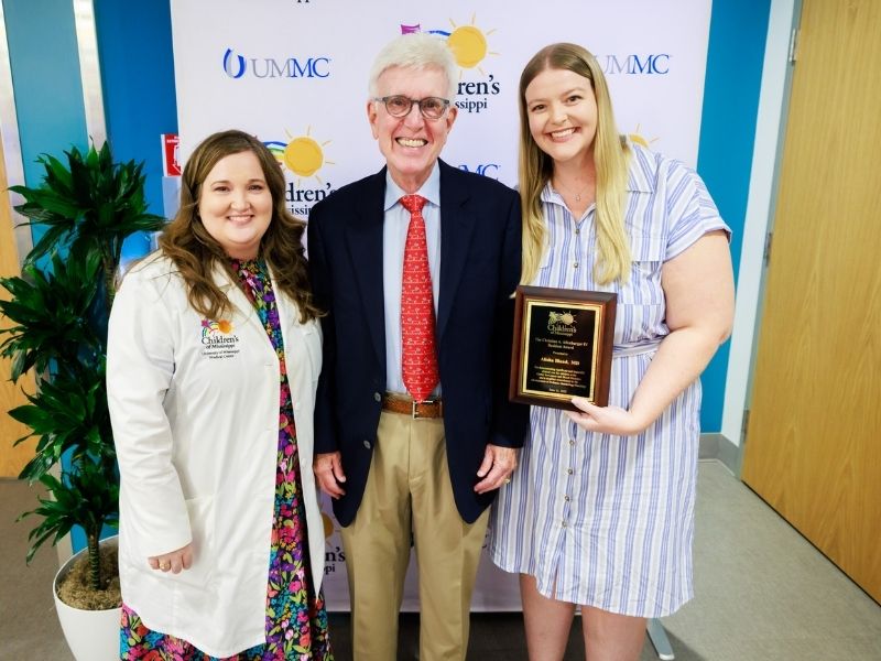 From left, Dr. Amanda Strobel, associate professor and fellowship director at UMMC, and Christian A. Allenburger III congratulate Dr. Alisha Bland on receiving the Christian A. Allenburger IV Resident Award during a ceremony at the Center for Cancer and Blood Disorders at Children’s of Mississippi June 12.