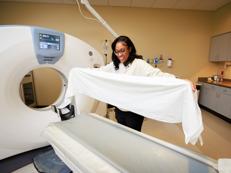 CT Technologist Kristin Roby preps CT scan machine for the next patient.