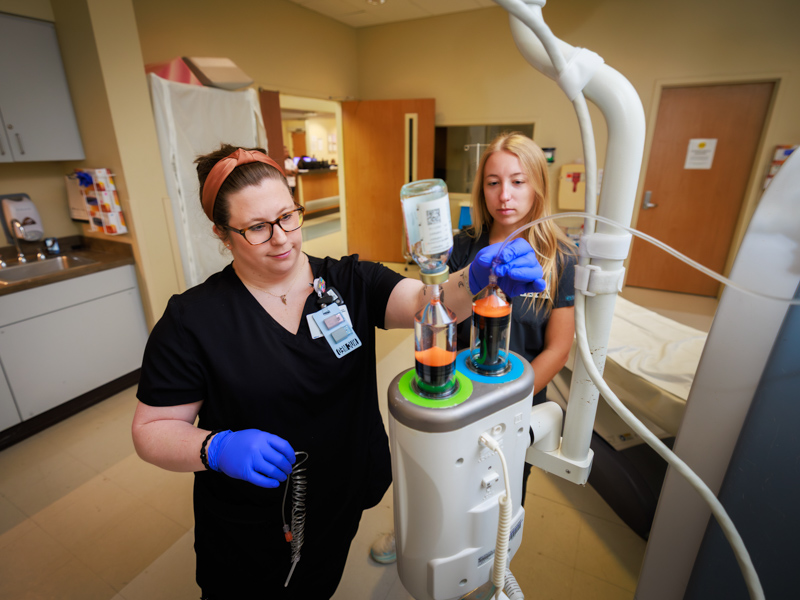 Registered Nuclear Medicine Tech Lacey Johnston, left, and UMMC Radiologic Sciences student Lauren Dungan refill vials containing a contrast agent for imaging.