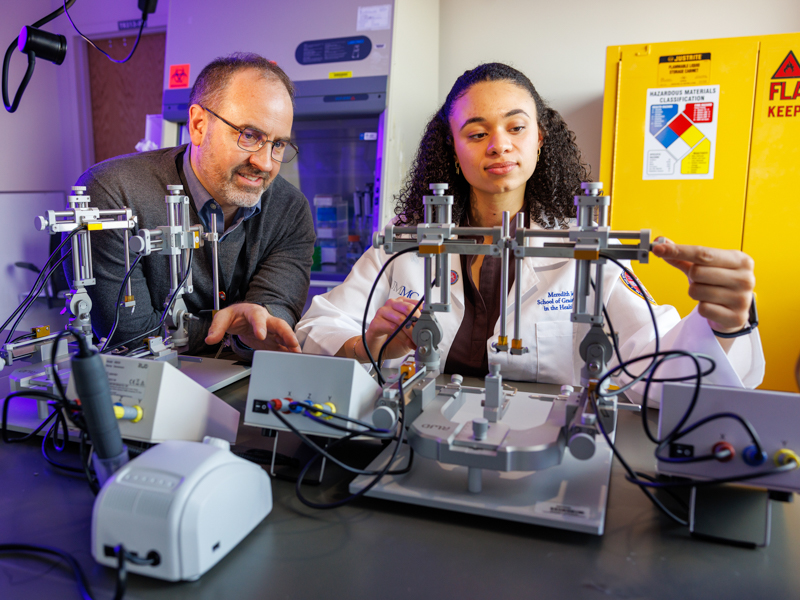 Dr. Kevin Freeman, left, instructs MD-PhD student Johnson on the use of a stereotaxic apparatus for intracranial implants and infusions