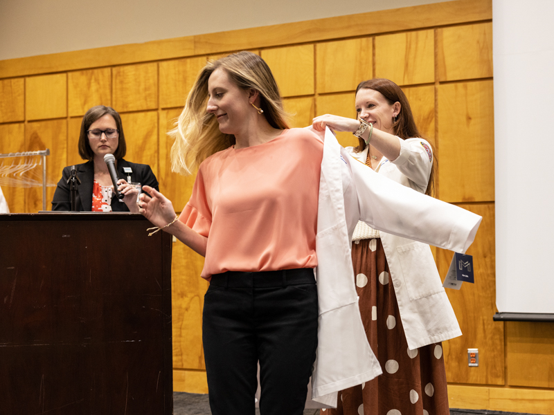 MD-PhD student Griffin dons her white coat with an assist from SGSHS Dean Dr. Sydney Murphy.