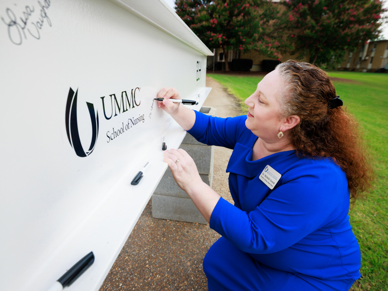 Dr. Michelle Goreth, president of the UMMC School of Nursing Alumni Association, smiles after signing the beam shortly before the topping-out ceremony. Joe Ellis/ UMMC Communications