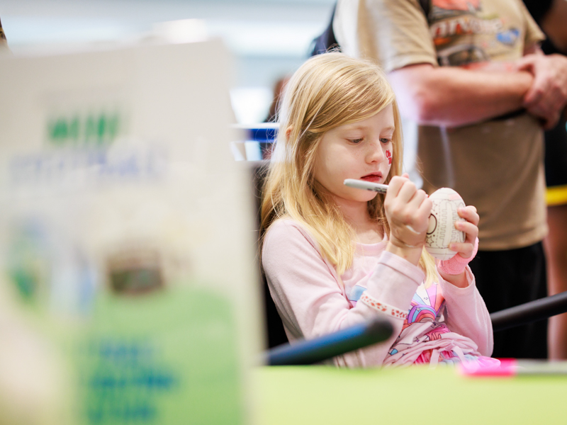 Children's of Mississippi patient River Bennett of Richland decorates a small football.