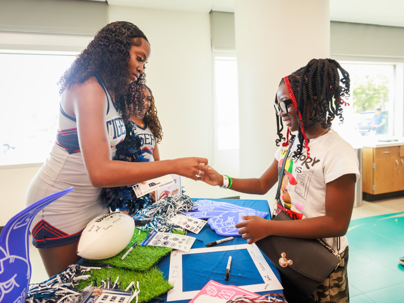 Tamai McGee of Yazoo City receives a sticker from Jackson State University cheerleader Tylah Morgan. Joe Ellis/ UMMC Communications