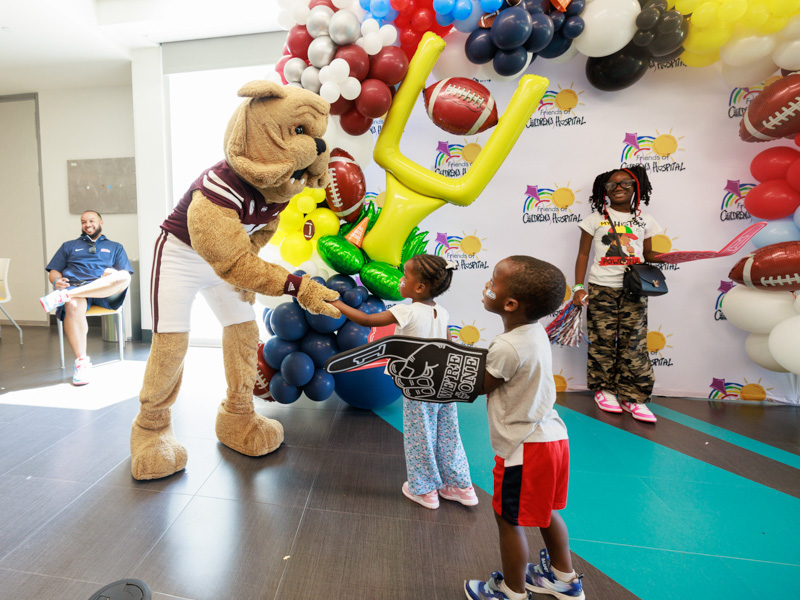 Mississippi State University mascot Bully shakes hands with Children's of Mississippi patient Khalea McGee of Yazoo city as siblings Craig and Tamai look on. Joe Ellis/ UMMC Communications