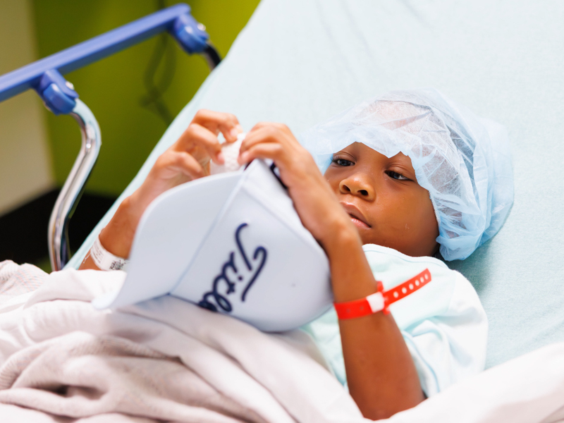 Children's of Mississippi patient Danny Womack, 7, of Leland awaits surgery with goodies from visiting players.