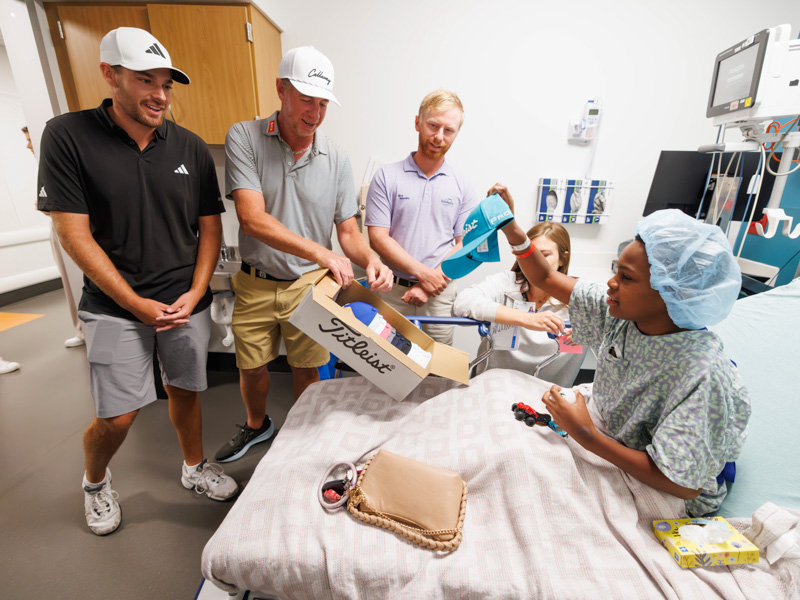 Sanderson Farms Championship pro-golfers, from left, Aaron Wise, Vince Covello and Anders Albertson visits with patient Christon Braddock, 14, of Pearl alongside Child Life Specialists Manager Cara Williams.
