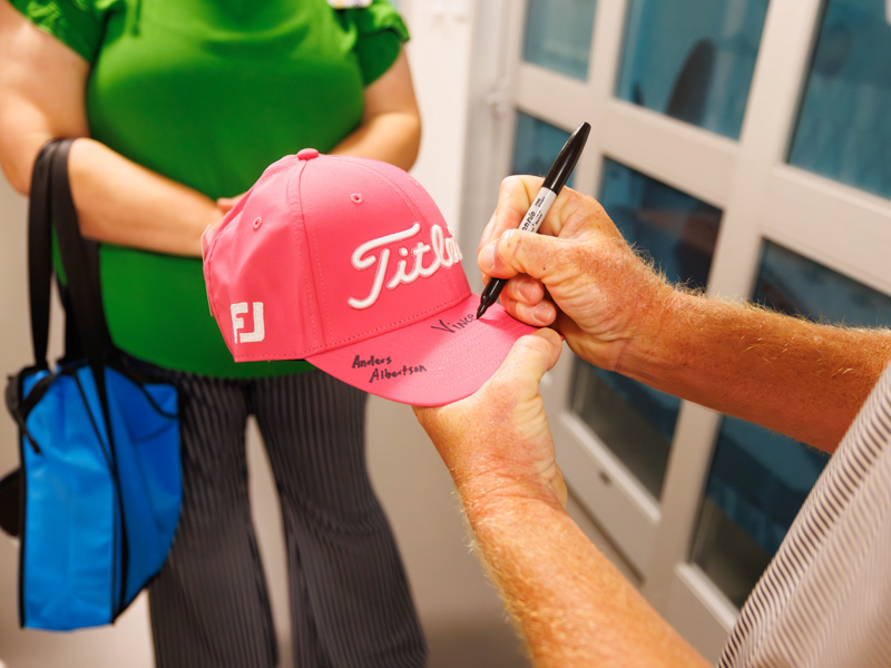 Golfers visiting Children's of Mississippi ahead of the Sanderson Farms Championship sign cap for a patient.