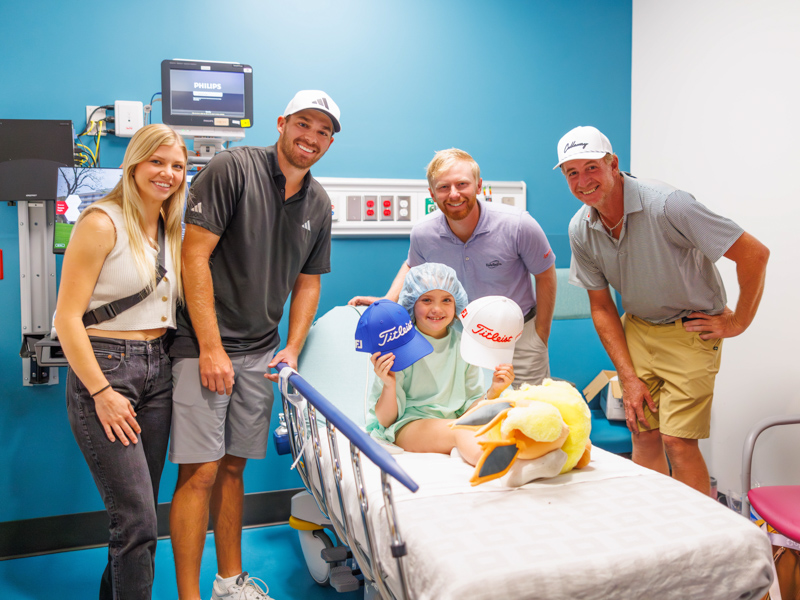 Sanderson Farms Championship pro-golfers, from left, Aaron Wise and his wife, Reagan, Anders Albertson and Vince Covello pose with patient Vera Previto, during a tour of the Children's of Mississippi pre-op area .
