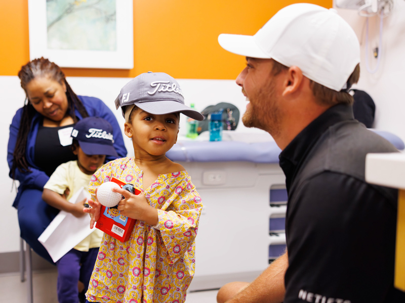 Sanderson Farms Championship pro-golfers Aaron Wise gets to know patient Nofi Martin during a tour of Children's of Mississippi Center for Cancer and Blood Disorders.