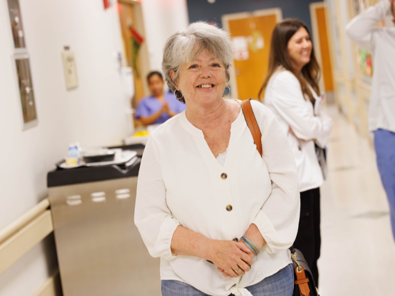Bone Marrow Transplant patient Penny Perkins is all smiles walking back into the unit that saved her life.