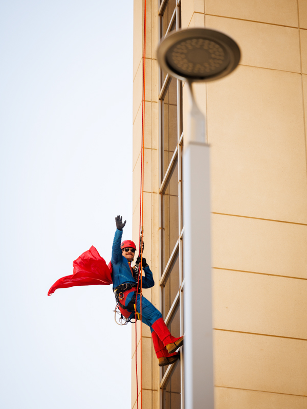 Superman waves to onlookers at the opening of Mimi's Playground.