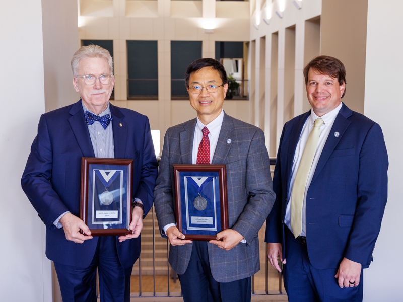 Dr. Lee Bidwell, right, associate vice chancellor for research, congratulates platinum medallion winners Dr. Gailen Marshall, R. Faser Triplett Chair of Allergy and Immunology and Billy S. Guyton Distinguished Professor, and Dr. Lei Zhang, professor and associate dean for research and scholarship in School of Nursing, Billy S. Guyton Distinguished Professor and Harriet G. Williamson Endowed Chair of Population Health Nursing.