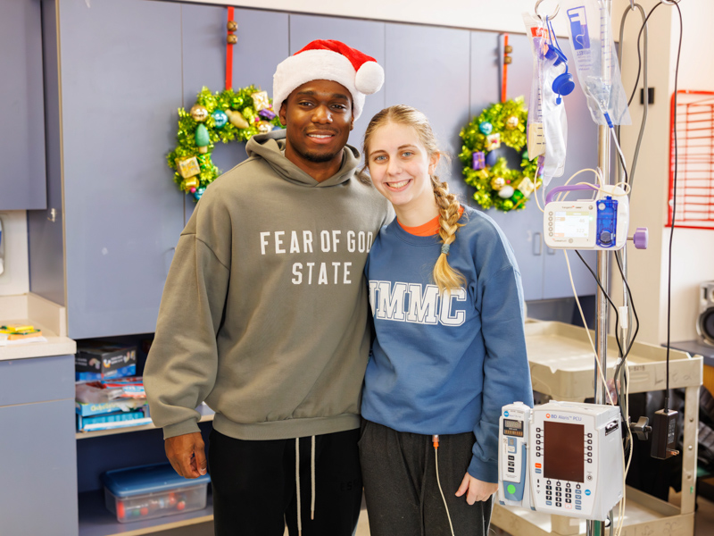 MSU basketball player Josh Hubbard gifts Ainsley Johnson, 16, with a Christmas present. Melanie Thortis/ UMMC Communications