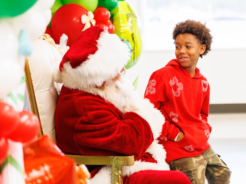 Michael Henderson III, 12, of Brandon talks with Santa about his Christmas List at Santa's Workshop. Melanie Thortis/ UMMC Communications