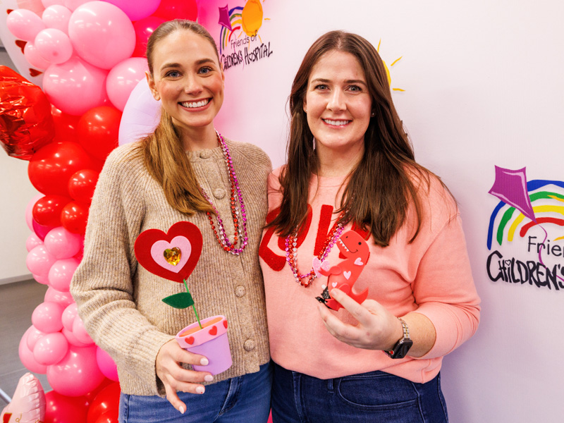 Caitlin Foreman, Executive Director of Friends of Children's and Blair Gunter, Community Relations and Events Manager pose with Valentine's crafts. Jay Ferchaud/ UMMC Communications
