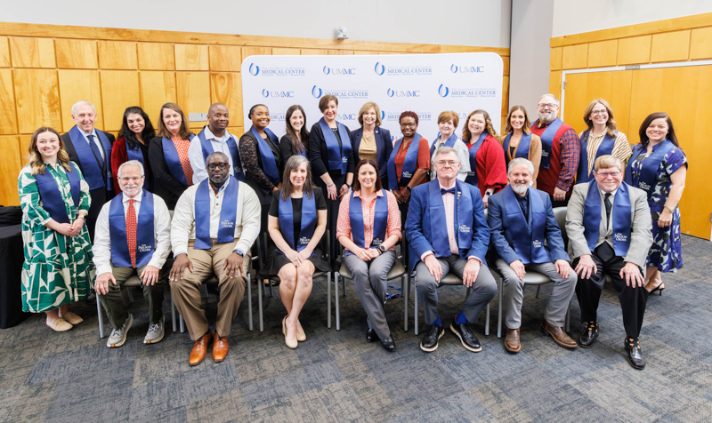 Dr. LouAnn Woodward, back row, ninth from left, vice chancellor for health affairs and dean of the School of Medicine, congratulates TEACH Prize honoree Dr. Jeannette Simino, front row, fourth from left, and her fellow Nelson Order inductees, front row, from left: Dr. David Brown, Dr. Jan Michael Williams, Dr. Susanna “Asher” Street Beam, (Simino), Dr. Carl Mangum II, Dr. Justin Sherman, and Dr. Harold Mark Livingston; back row, from left: Dr. Casey Boothe, Dr. Douglas Vetter, Kayla Abraham, Dr. Melanie Lauderdale, Dr. Joshua Jefferson, Dr. Kristen Alston, Kelsey Welch, Dr. Bulem Yuzugullu Tutunculer, (Woodward), Dr. Leneise Lynn, Dr. Lori Duke, Mary "Melissa" McBride, Dr. Amanda Clark, Dr. Samuel Dickinson, Dr. Kimberly "Kim" Paduda and Dr. Alicia Ciarloni. Not pictured: Dr. Praise Matemavi.