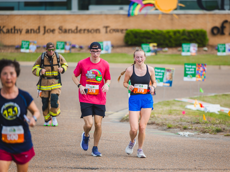 Various half marathon runners race by Children's of Mississippi at the 2026 Run the Rainbow benefitting the children's hospital.