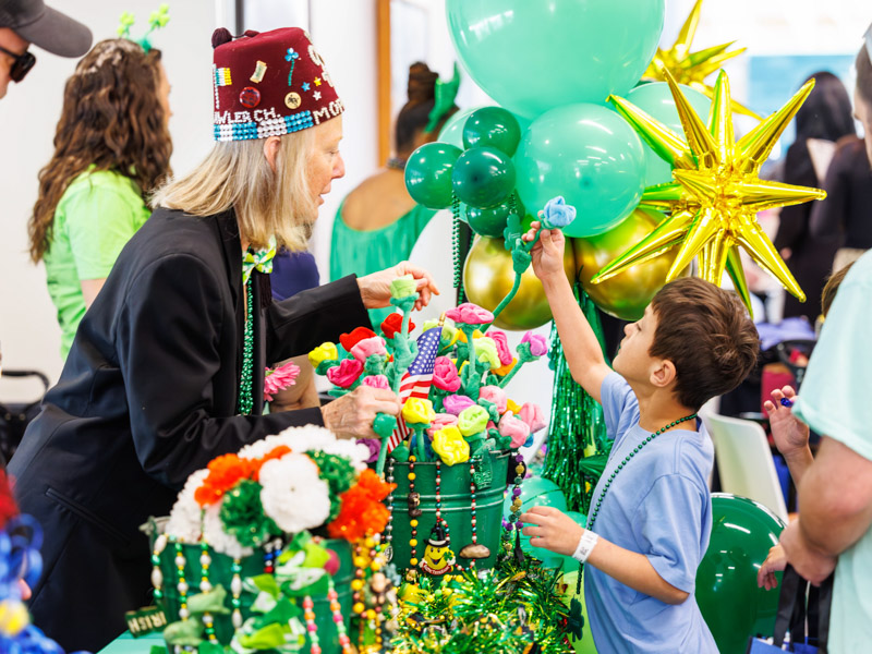 Krewe O’Tux member Karen Gilder gives a prize to Robert Whisenant, 8, of Gulfport at the Petite Parade at the children's hospital. Melanie Thortis/ UMMC Communications