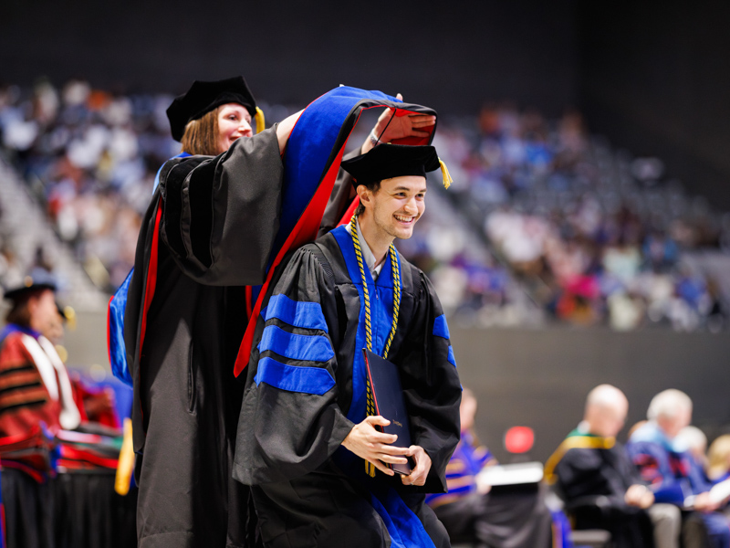 Brian David Christman is hooded after receiving his PhD in biostatistics and data science.