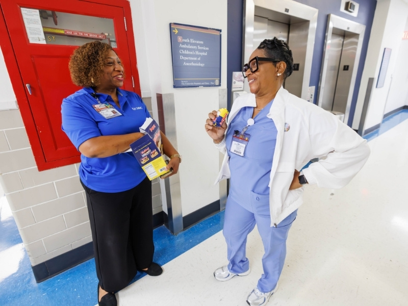 Pamela Greenwood, senior employee relations representative with Human Resources, gives Sharon Arnold, unit secretary for bone marrow, an ice cream sandwich as part of employee appreciation week. Melanie Thortis/ UMMC Communications