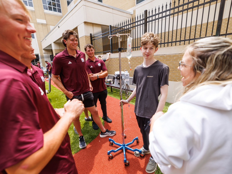 Dylan Pearson, 17, of Petal and his mom, Amy, visit with MSU baseball players.