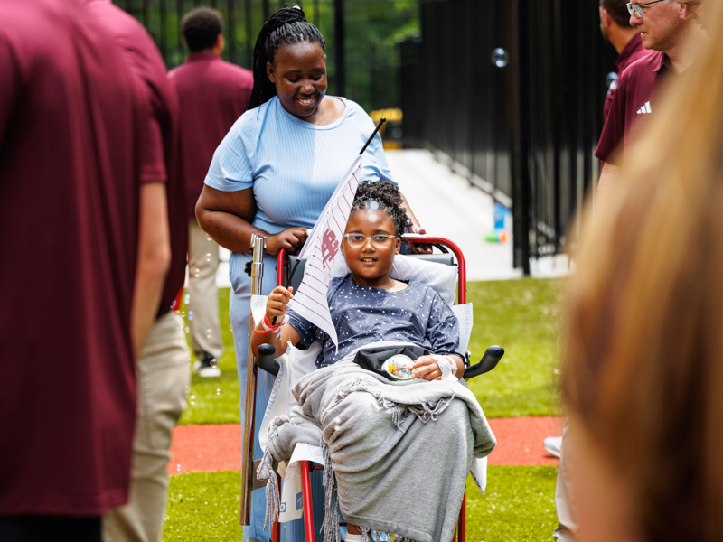Journee Burns, 7, of Starkville visits with baseball players from MSU.
