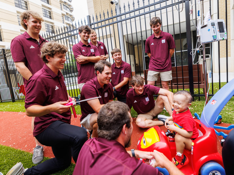 David Evangelista, 3, of Clinton catches bubbles with Mississippi State University baseball players at Mimi's playground outside the children’s hospital.