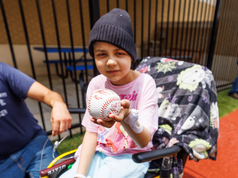 Aaliyah DeLeon, 10, shows off her baseball gifted to her by MSU players.