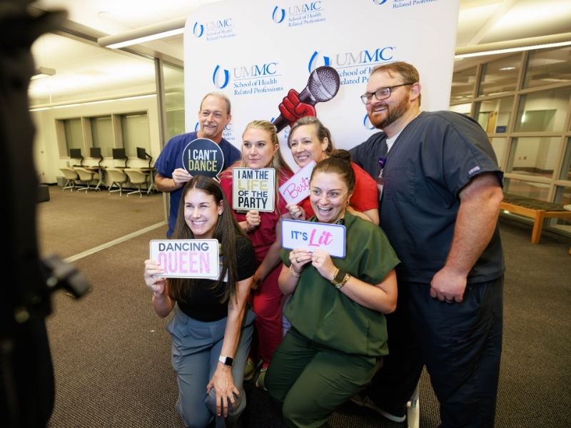 Employee Appreciation Week brought out the smiles in the SHRP building as radiologic sciences employees, from left, Lee Brown, Kayla Burchfield, Brittany Bush, Asher Street Beam, Shae Wrenn and Zack Gray pose in the photo booth. Melanie Thortis/ UMMC Communications