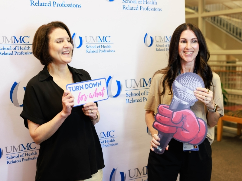 Dr. Lisa Morton, left, and Dr. Britney Reulet, chair of health systems administration, pose in the photo booth as part of Employee Appreciation Week. Melanie Thortis/ UMMC Communications