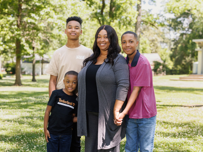 Taylor smiles with sons Jayden Taylor, left, Micah Spann, front, and Logan Taylor.