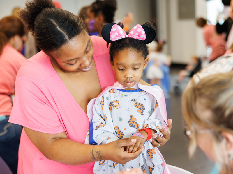 Reilynn Gibson, 3, of Indianola admires her pink hand paint at Disney Day at the children's hospital.