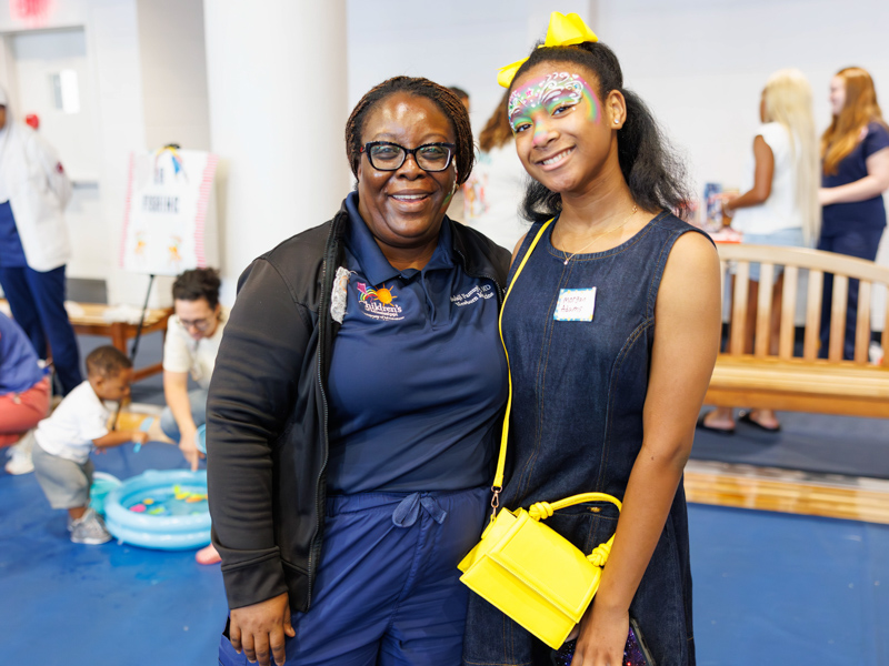 Dr.Bolaji Famuyide, Chief of pediatric neonatology and former NICU patient Morgan Adams reunite for a photograph at the children's hospital's NICU reunion.
