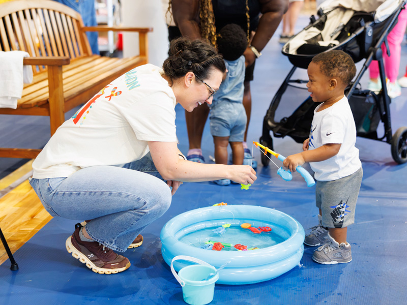 Amanda Prince, an RN in the NICU, and Ace Brown, 1, have some fun fishing during the NICU reunion.
