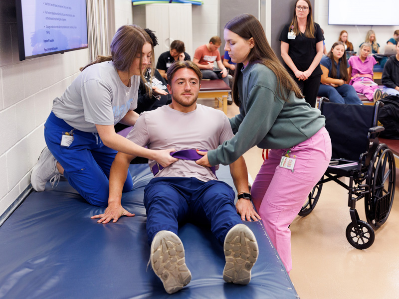 Cadence Tiller, Hagen Davis and Kaitlyn Hitt, all students in the Doctor of Physical Therapy program, participate in Acute Care in Physical Therapy II class in the PT lab.