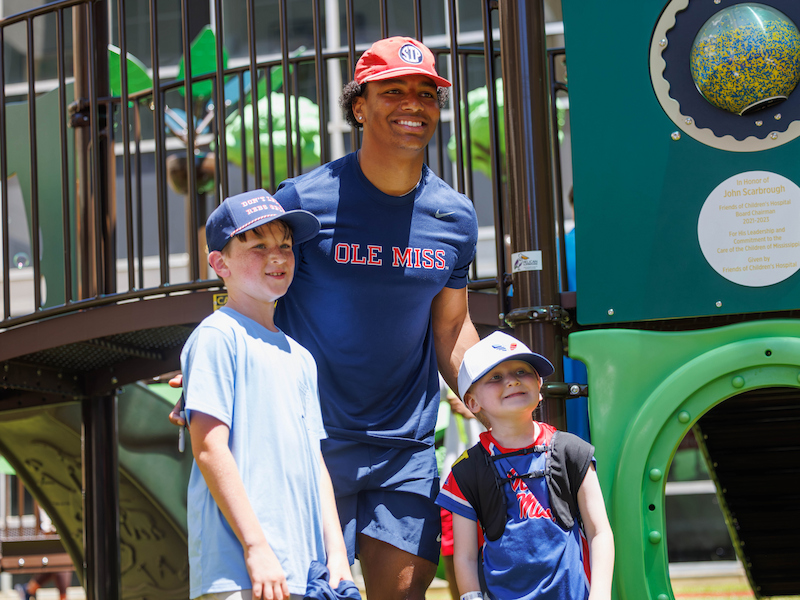 Ole Miss quarterback Trinidad Chambliss poses for a photo with Ledger Smith, 6, of Brookhaven with his brother Beckam during a team visit to Children's of Mississippi.