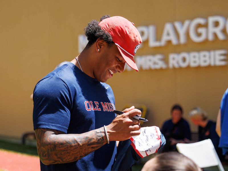 Ole Miss quarterback Trinidad Chambliss signs his autograph for a patient during a team visit to Mimi's Playground at Children's of Mississippi.