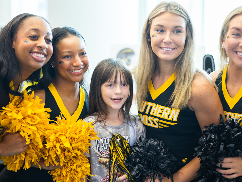 Anniston Strickland, 8, of Petal meets University of Southern Mississippi cheerleaders at Tailgating with Friends.