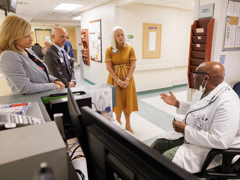 Dr. Asuquo Esuabana, seated, an emergency room physician at UMMC Greenwood, discusses the facility's new chapter. He speaks with Dr. LouAnn Woodward, vice chancellor for health affairs, Dr. Alan Jones, associate vice chancellor for health affairs and Dodie McElmurray, the CEO of University and Community Hospitals.