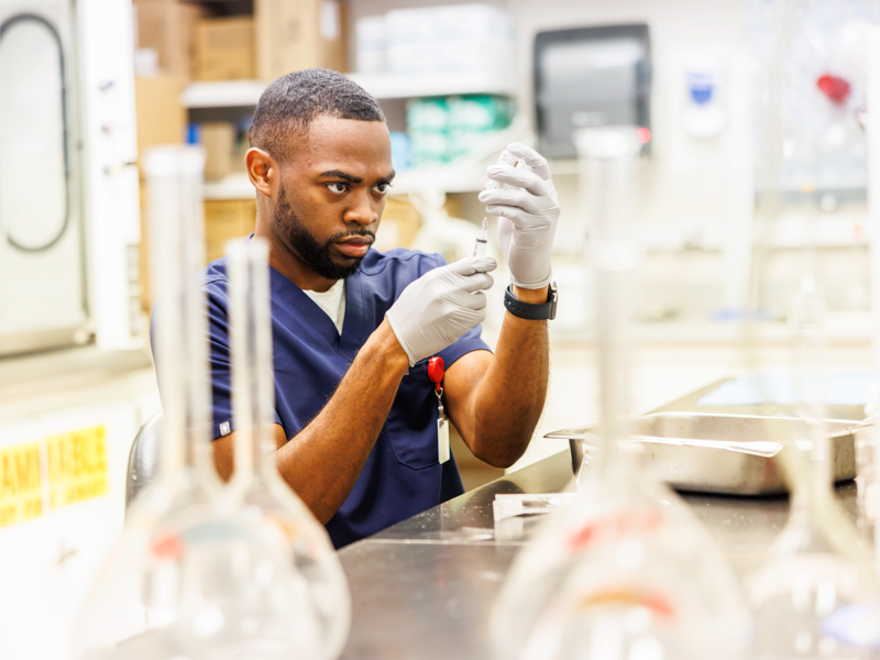 Young examines a research sample as part of his laboratory work investigating the connection between sleep and addiction.