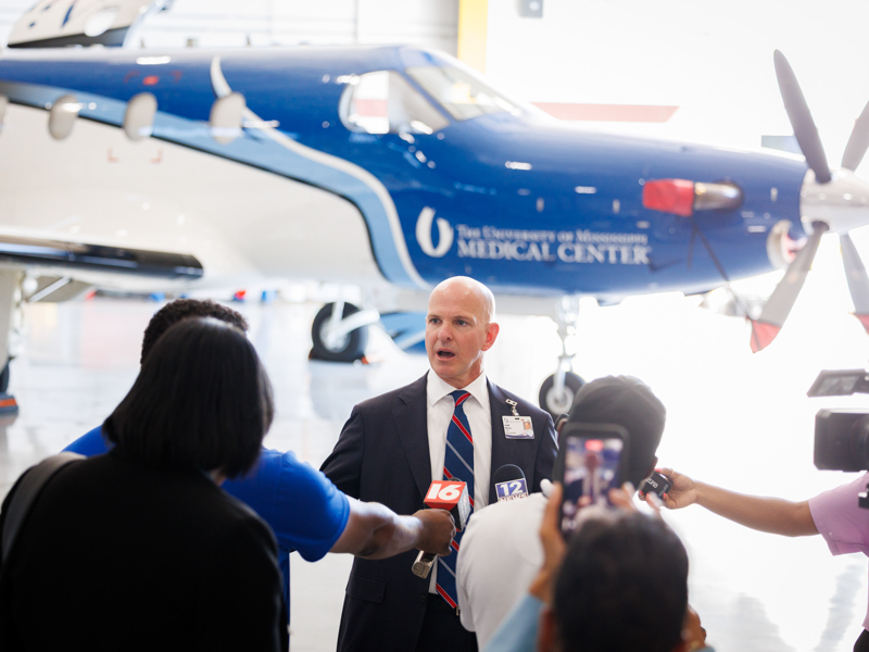 Dr. Kendall McKenzie, chair of the Department of Emergency Medicine, pictured center, speaking with media outlets about the new addition to the University of Mississippi Medical Center’s AirCare fleet, the Pilatus PC-12.