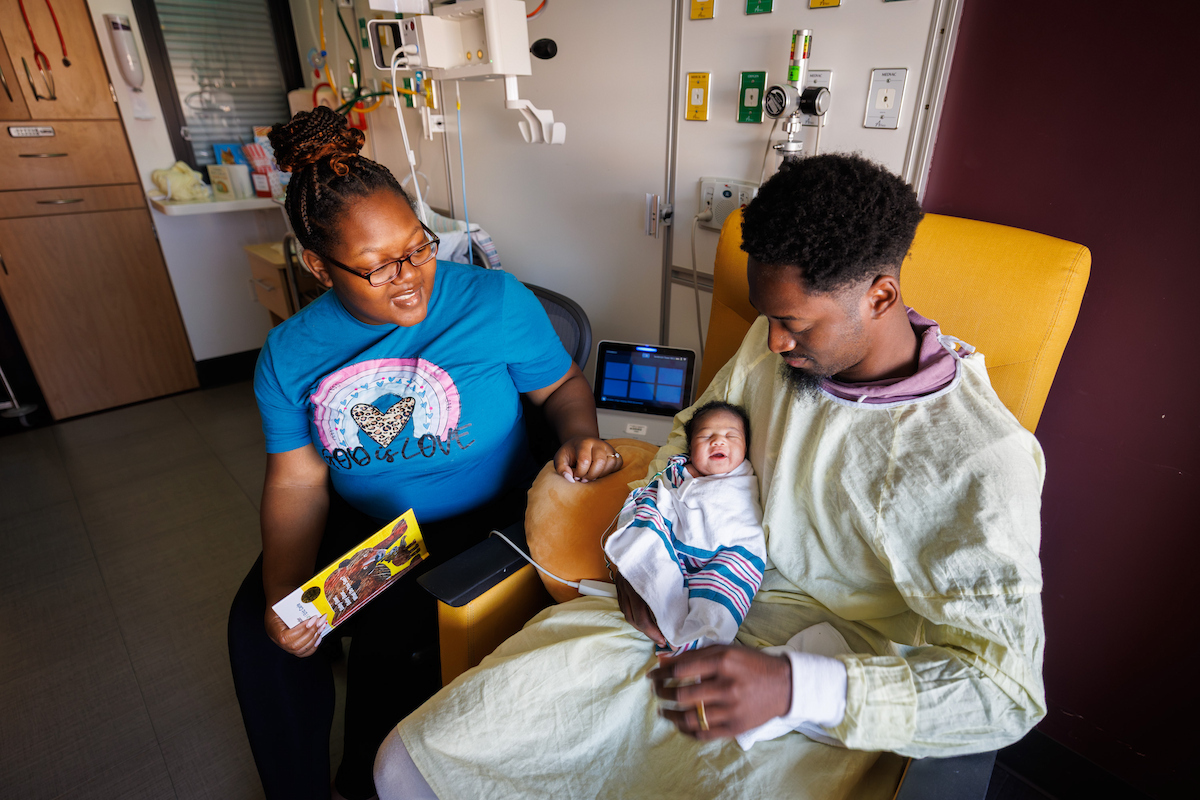 Charis Jennings, of Union is all smiles while being read to by her parents during Read-A-Thon at the children's hospital.