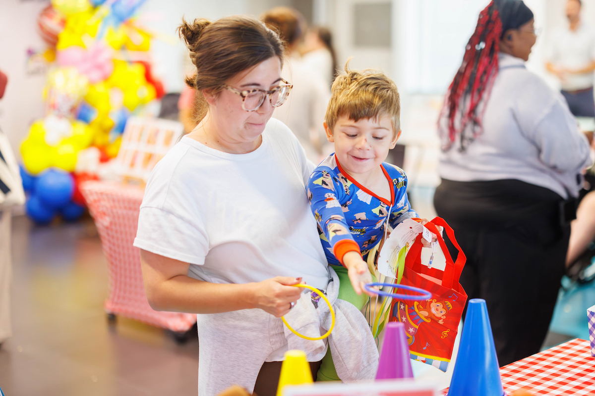 Matthew Bernard, 3, of Jackson plays ring toss during Fair with Friends at the children's hospital.