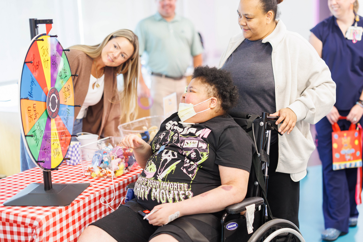 Issiah James, 14, of Jackson spins the prize wheel during the Fair with Friends event at the children's hospital.
