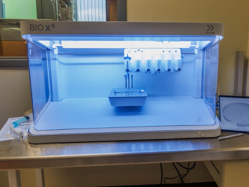 UMMC’s new 3D bioprinter can combine living cancer, fat, bone and immune cells in laboratory models, helping researchers study how a tumor’s surroundings influence its growth, spread and response to treatment.