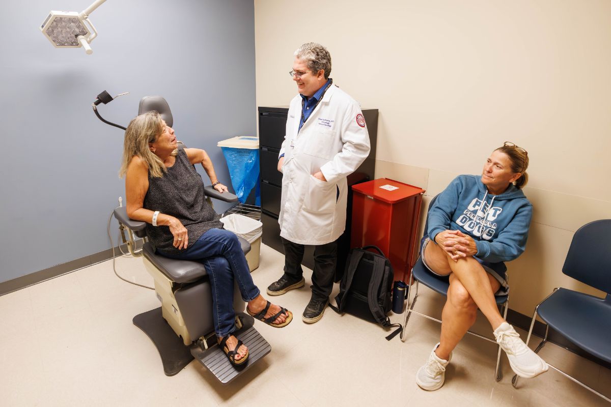 CCRI patient Cynthia Clem talks with Dr. Mark Anderson during a visit to the UMMC Cancer Center and Research Institute. At right is her sister, Karen Clem.