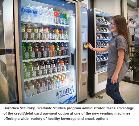 Dorothea Staursky, Graduate Studies program administrator, takes advantage of the card payment option at a vending machine. 
