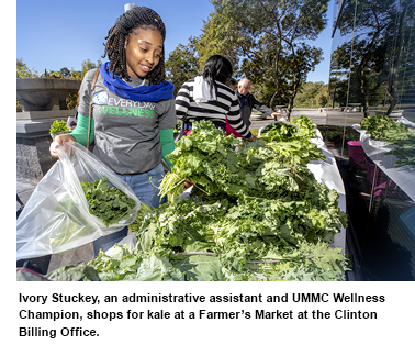 Ivory Stuckey, an administrative assistant and UMMC Wellness Champion, shops for kale at a Farmer’s Market at the Clinton Billing Office.
